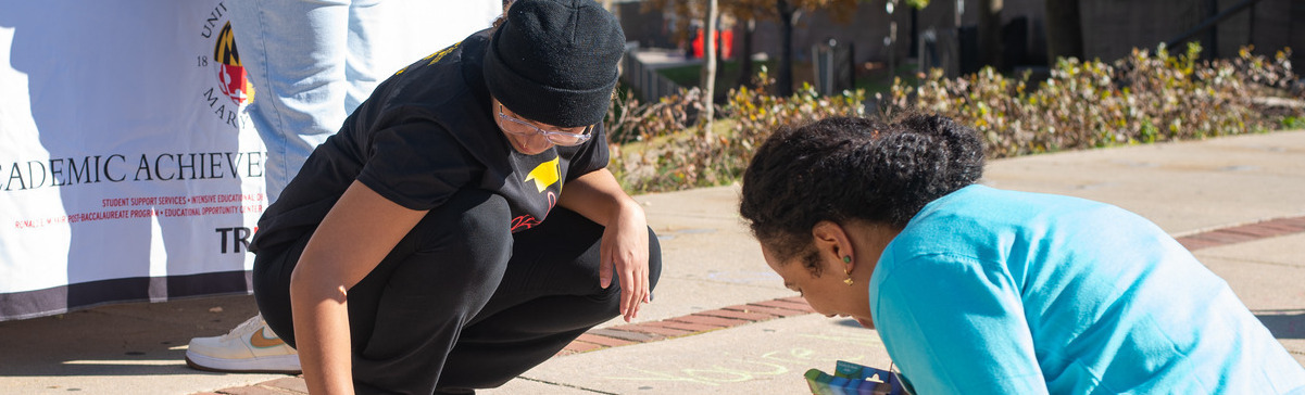 Students and staff writing in chalk