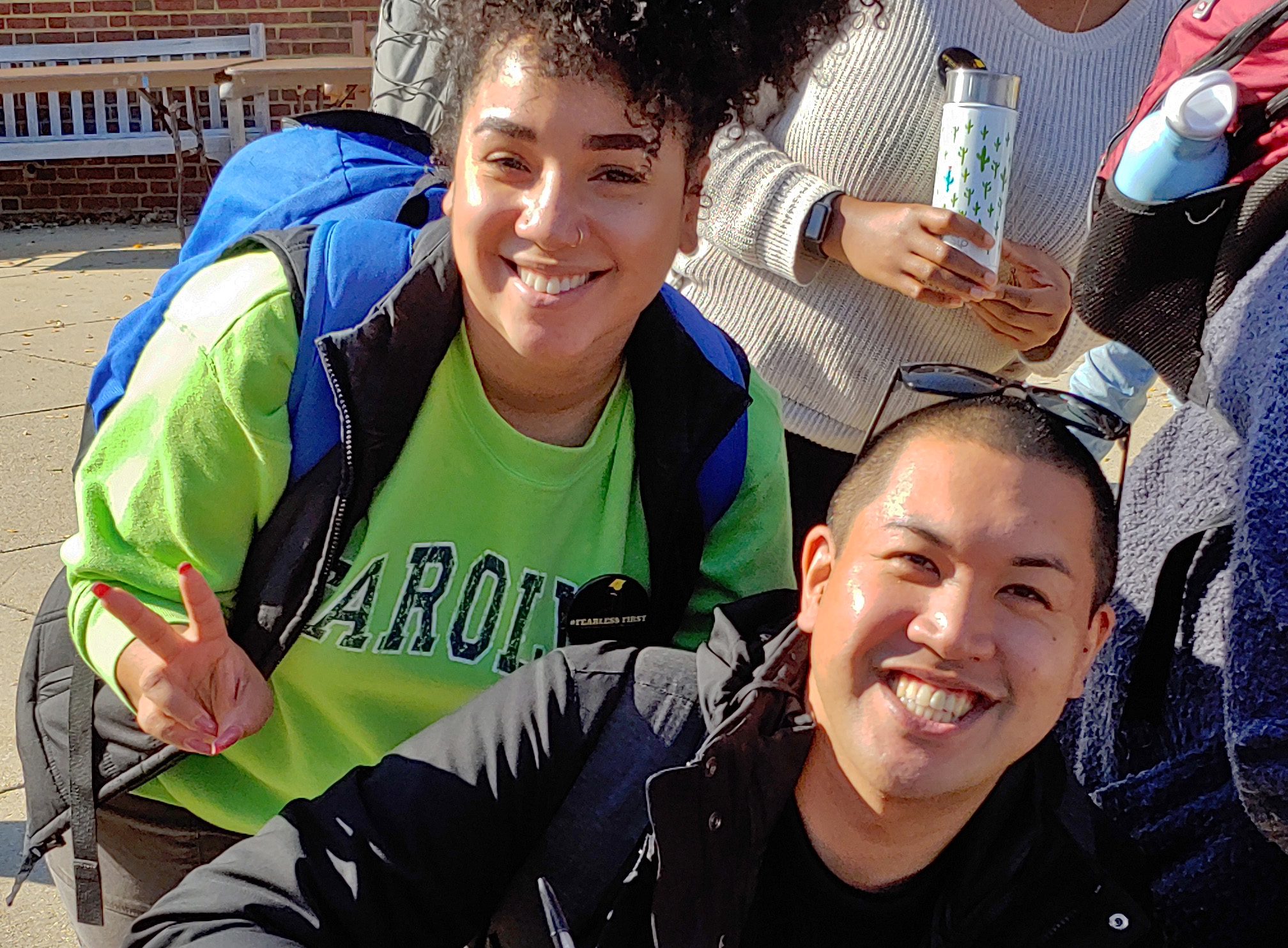 three students look up from table and smile