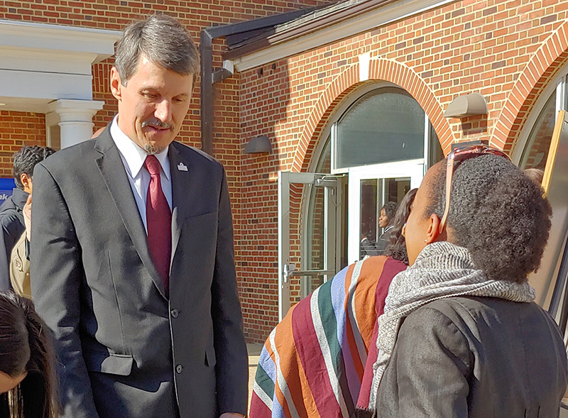 man in suit talks to student